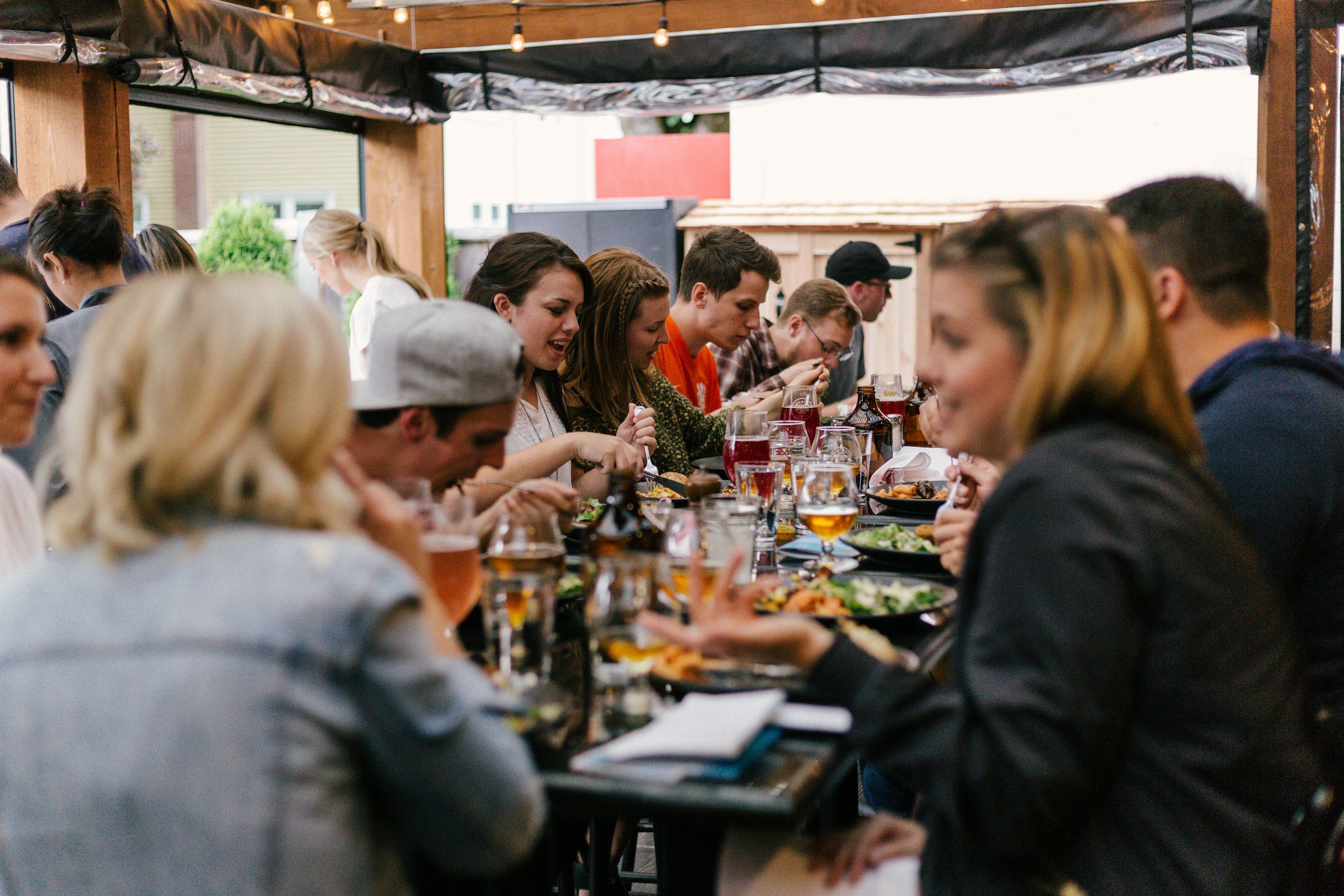 Guests on a food tour share plates and stories around a long table